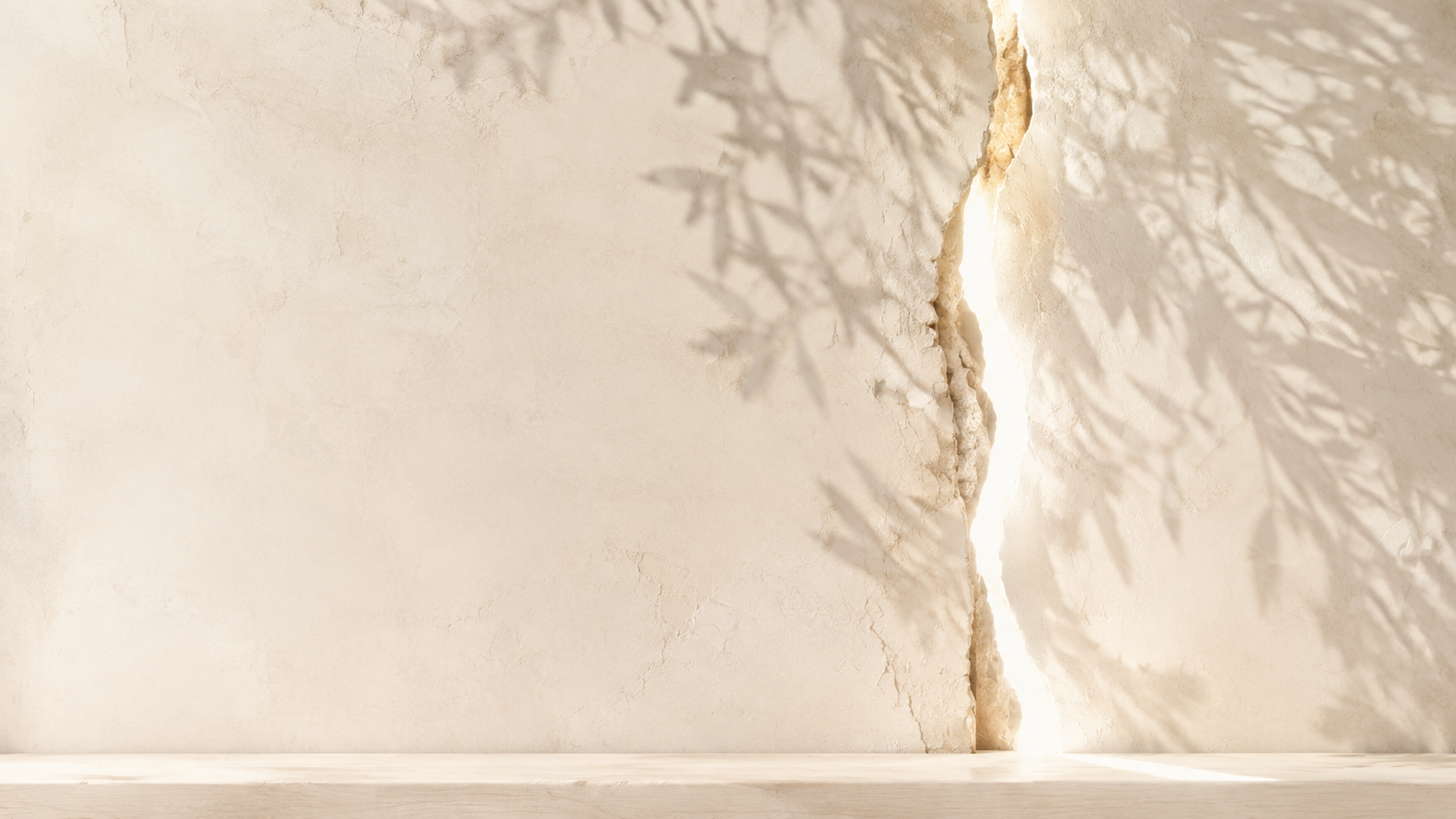 Warm natural light shining through a crack in an ivory plaster wall