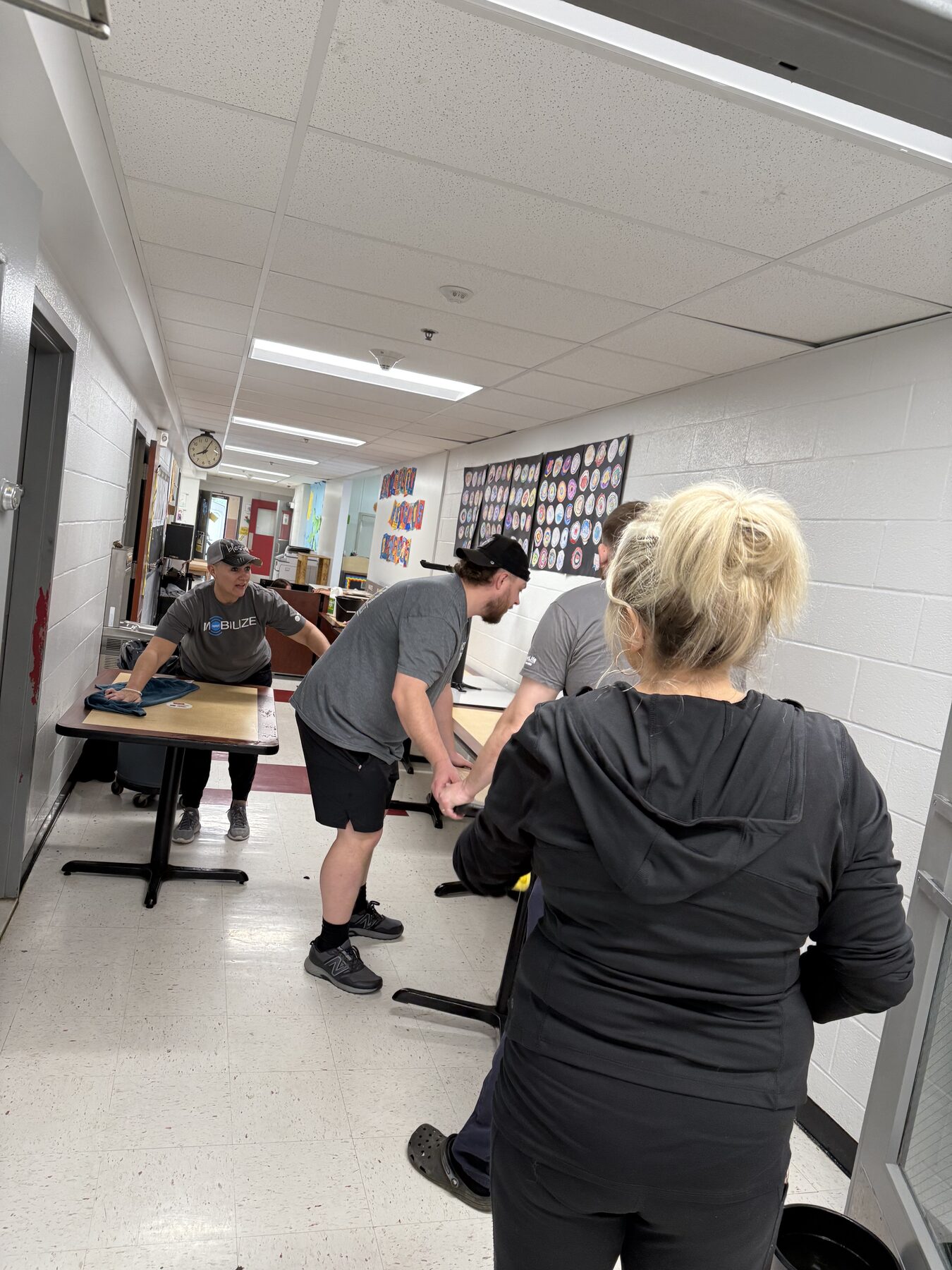 Volunteers moving and cleaning classroom furniture