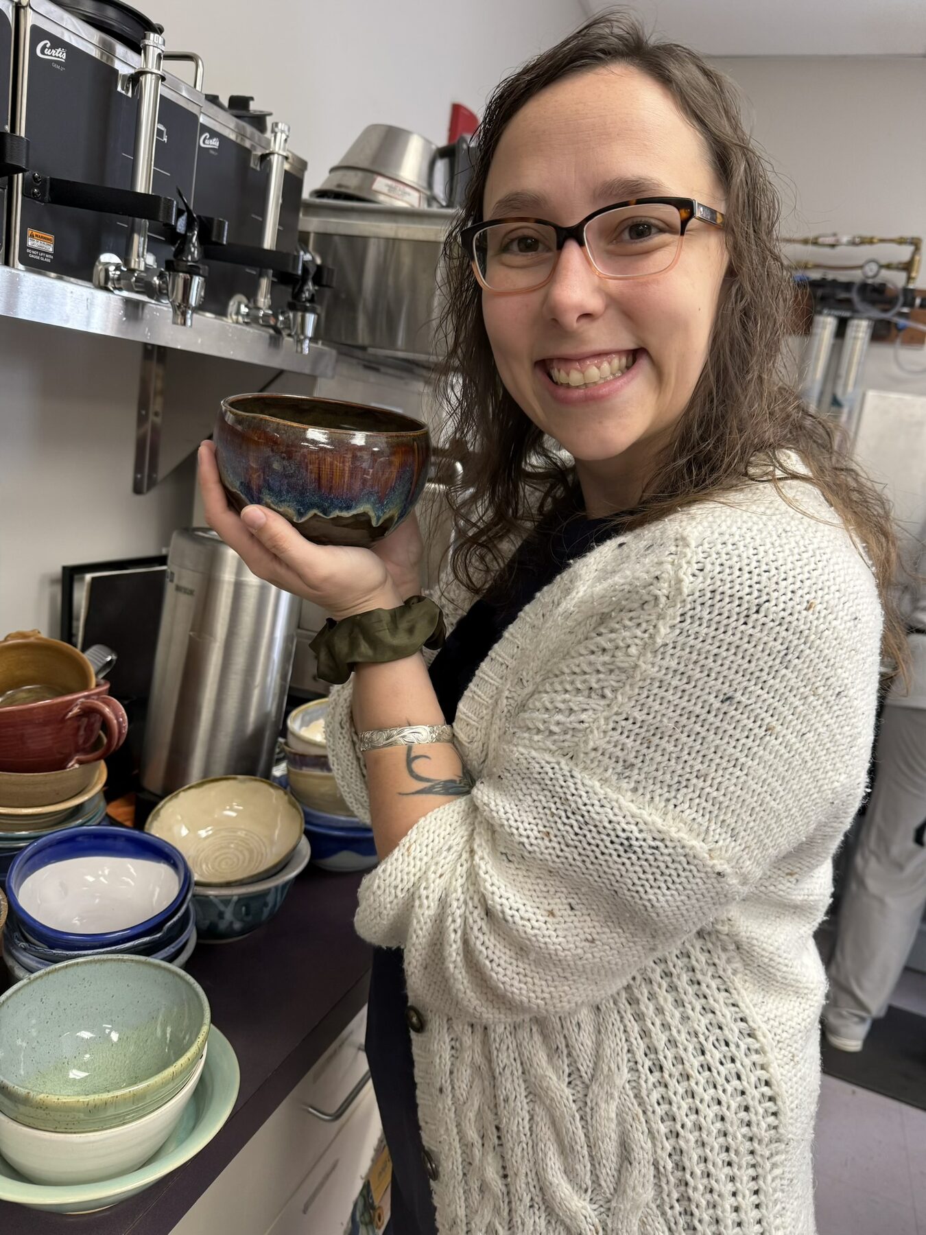 A volunteer holding a handmade bowl while preparing community resources